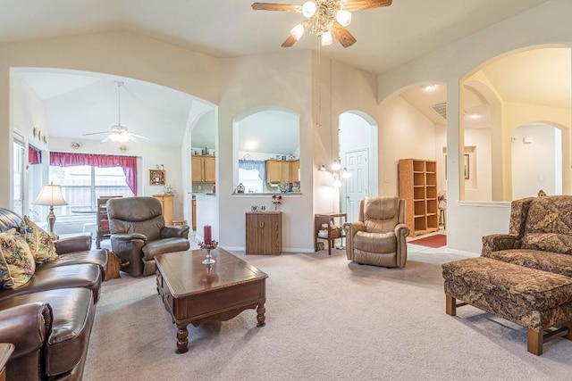 carpeted living area with a ceiling fan, arched walkways, baseboards, and lofted ceiling