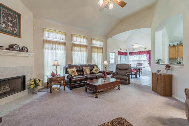 living area with a ceiling fan, light colored carpet, and a tile fireplace
