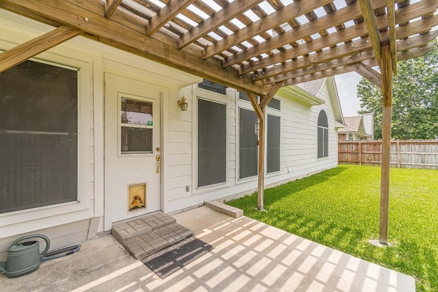 view of exterior entry with a lawn, a patio area, fence, and a pergola