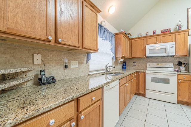 kitchen with a sink, white appliances, decorative backsplash, light tile patterned floors, and vaulted ceiling