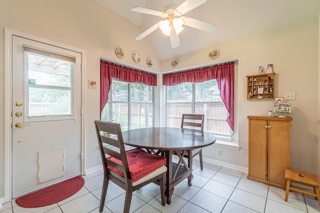 dining space featuring a ceiling fan, baseboards, vaulted ceiling, and light tile patterned floors