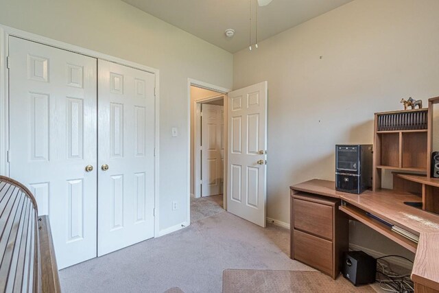 home office featuring baseboards, a ceiling fan, and light carpet