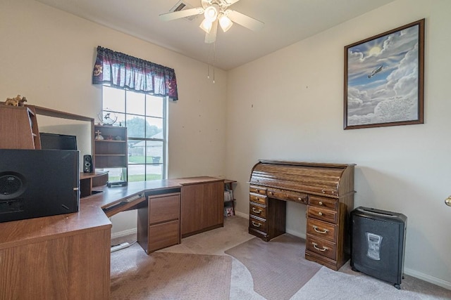 office area with baseboards, ceiling fan, and light carpet