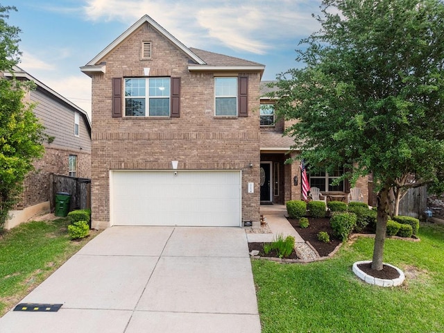 traditional home with brick siding, driveway, a front lawn, and a garage