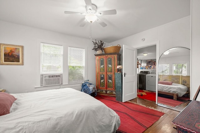 bedroom with separate washer and dryer, a ceiling fan, wood finished floors, and cooling unit