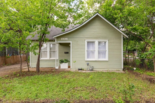 642 Tillery St, Austin, TX 78702 - bungalow-style house featuring fence, a shingled roof, and a front lawn