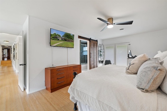 1712 Mccoy Pl, Georgetown, TX 78626 - bedroom featuring a barn door, light wood-style flooring, a ceiling fan, and baseboards