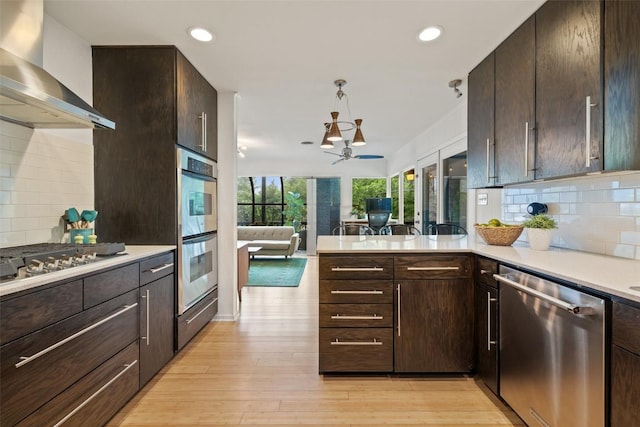 1712 Mccoy Pl, Georgetown, TX 78626 - kitchen with appliances with stainless steel finishes, wall chimney exhaust hood, light countertops, tasteful backsplash, and recessed lighting
