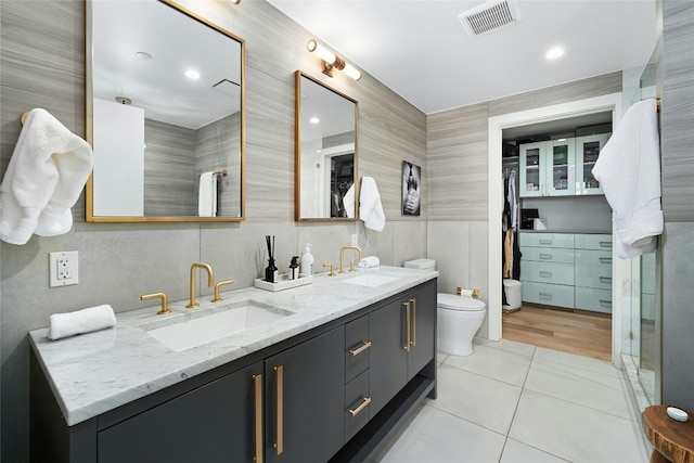 bathroom with visible vents, a sink, tile patterned floors, and tile walls