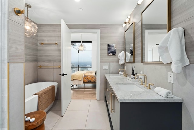 full bathroom featuring a sink, tile patterned flooring, ensuite bathroom, and a freestanding bath