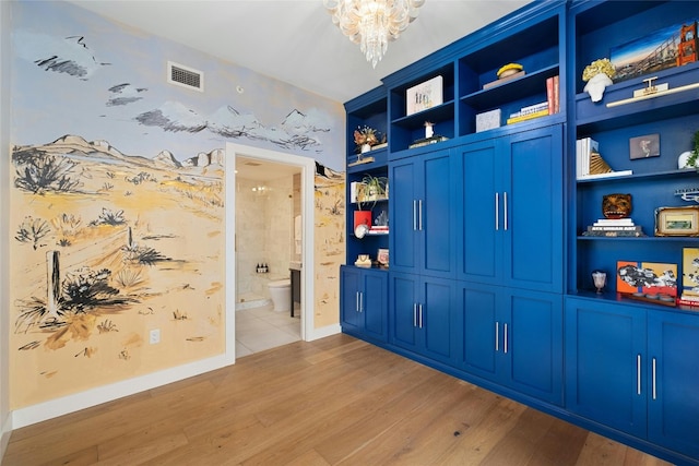 interior space featuring visible vents, light wood-style flooring, baseboards, and a chandelier