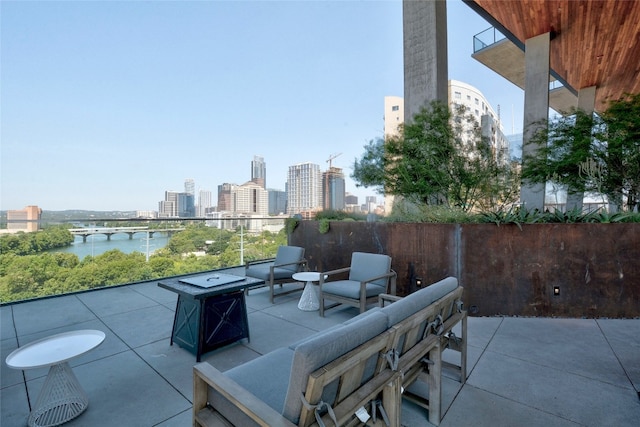 view of patio / terrace with a view of city, a water view, and an outdoor fire pit