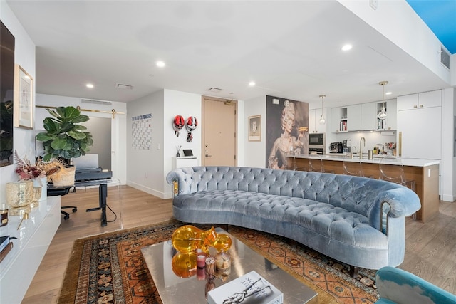 living area featuring recessed lighting, baseboards, visible vents, and light wood-style flooring