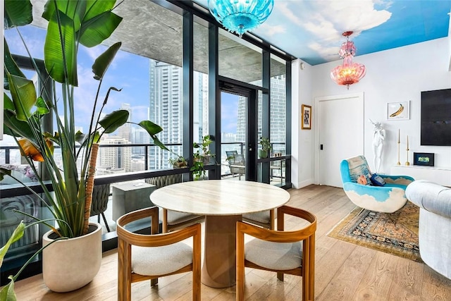 dining room featuring baseboards, floor to ceiling windows, and wood finished floors