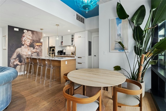 dining area featuring visible vents and light wood-type flooring