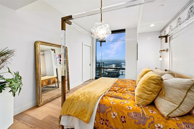 bedroom featuring baseboards, recessed lighting, light wood-style flooring, and a notable chandelier