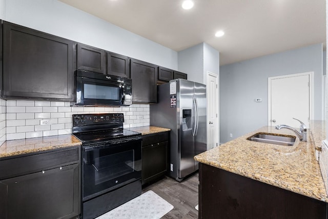 12717 Casting Dr, Manor, TX 78653 - kitchen with black appliances, dark wood-style floors, light stone counters, tasteful backsplash, and recessed lighting