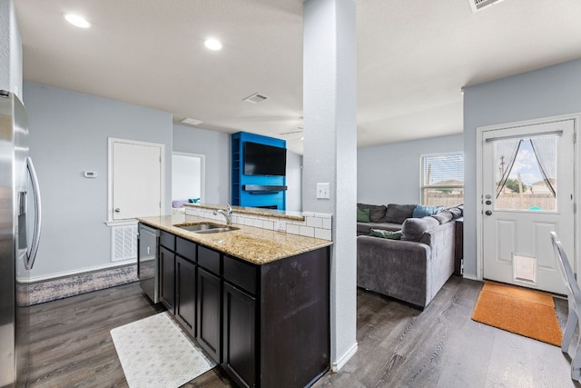 12717 Casting Dr, Manor, TX 78653 - kitchen featuring stainless steel appliances, open floor plan, dark wood-style flooring, light stone countertops, and recessed lighting