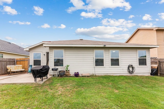 back of property with a lawn, fence, and a patio area
