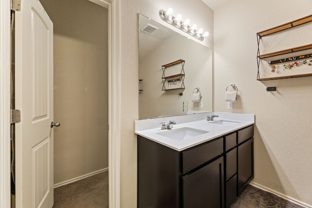 full bathroom with a sink, baseboards, double vanity, and visible vents