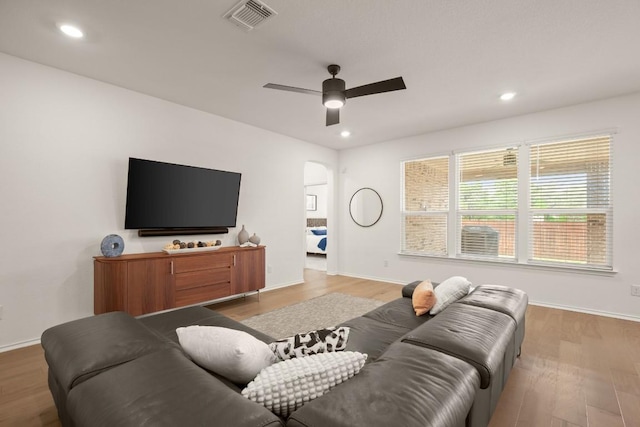 1625 Stinnett Dr, Leander, TX 78641 - living room featuring visible vents, wood finished floors, baseboards, arched walkways, and a ceiling fan