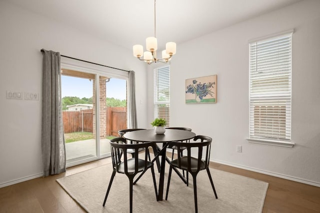 1625 Stinnett Dr, Leander, TX 78641 - dining area with an inviting chandelier, baseboards, and light wood finished floors