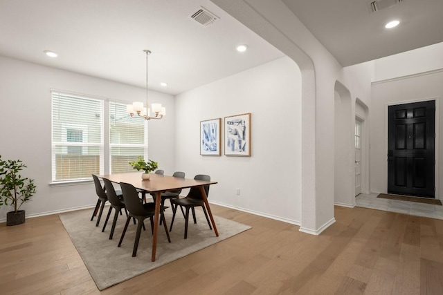 1625 Stinnett Dr, Leander, TX 78641 - dining space featuring arched walkways, baseboards, visible vents, and light wood-type flooring
