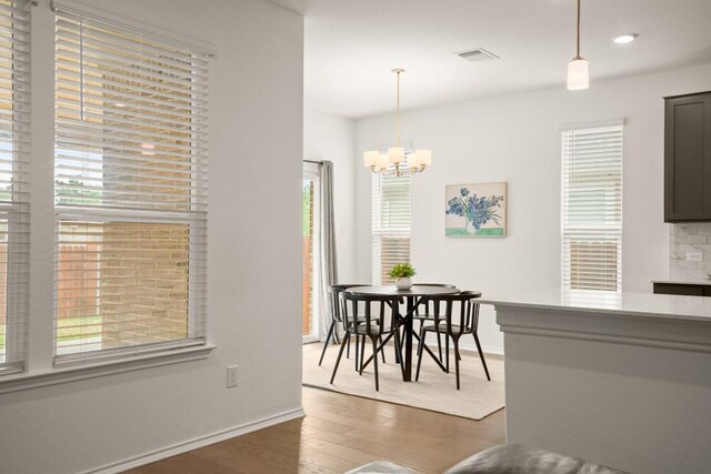 1625 Stinnett Dr, Leander, TX 78641 - dining room featuring visible vents, wood finished floors, baseboards, recessed lighting, and a chandelier