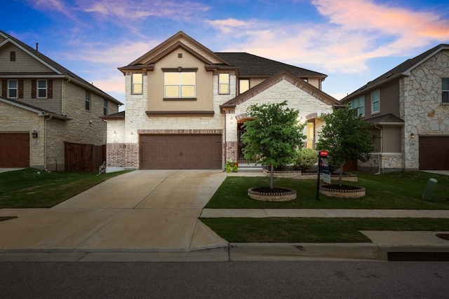 1625 Stinnett Dr, Leander, TX 78641 - view of front of property with a garage, stone siding, stucco siding, concrete driveway, and a lawn