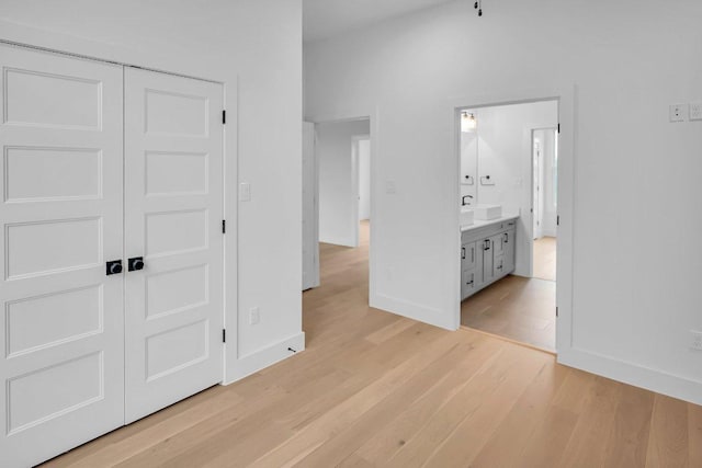 309 Alabaster, Horseshoe Bay, TX 78657 - unfurnished bedroom featuring baseboards, a closet, light wood-style flooring, and connected bathroom