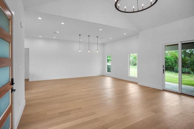 309 Alabaster, Horseshoe Bay, TX 78657 - spare room featuring recessed lighting, high vaulted ceiling, a chandelier, and light wood-style floors
