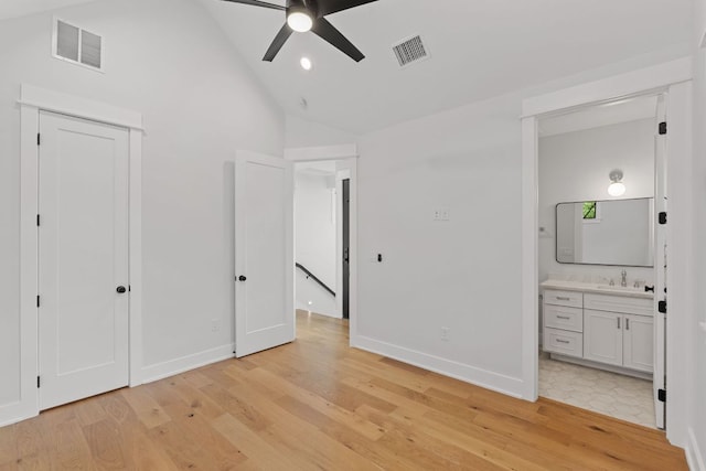 unfurnished bedroom featuring visible vents, a sink, light wood-style floors, and lofted ceiling