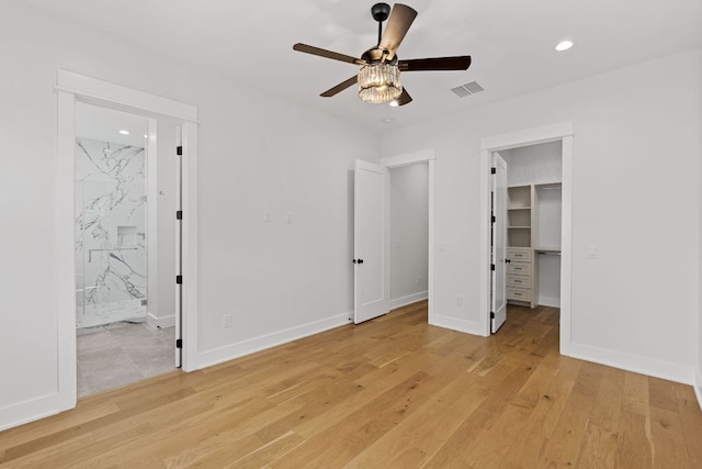 unfurnished bedroom with recessed lighting, a spacious closet, light wood-type flooring, and visible vents