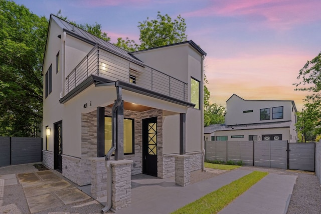 408 W 34th St, Austin, TX 78705 - view of front facade featuring stone siding, a balcony, stucco siding, and a gate