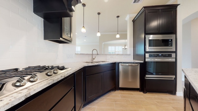 kitchen with backsplash, crown molding, a sink, stainless steel appliances, and extractor fan