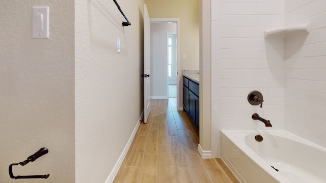 full bathroom with vanity, baseboards, shower / bath combination, and wood finished floors