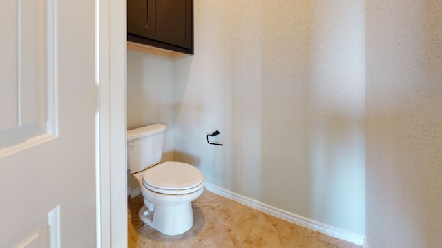 bathroom with tile patterned floors, baseboards, and toilet