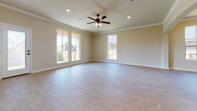 unfurnished room featuring arched walkways, ornamental molding, and ceiling fan