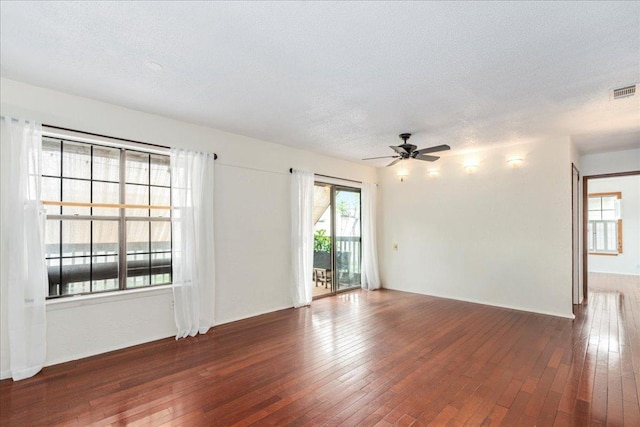 spare room featuring visible vents, a textured ceiling, ceiling fan, and hardwood / wood-style flooring