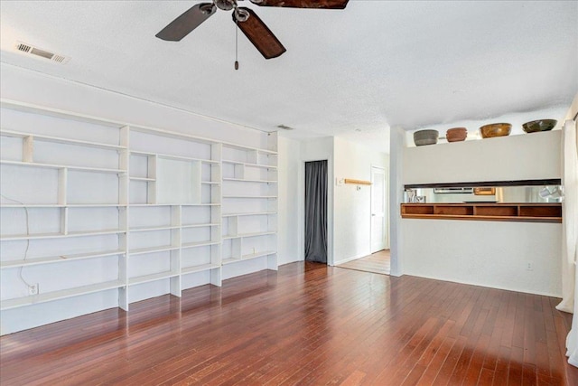 unfurnished living room featuring a ceiling fan, a textured ceiling, visible vents, and hardwood / wood-style floors