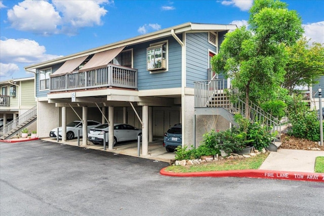 view of front of house featuring stairway and covered parking