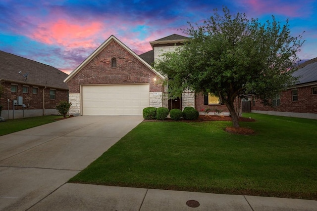 104 N Pasture Cv, Hutto, TX 78634 - view of front of home with a lawn, concrete driveway, a garage, and stone siding