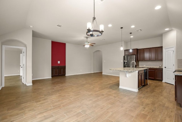 104 N Pasture Cv, Hutto, TX 78634 - kitchen with arched walkways, ceiling fan, open floor plan, a chandelier, and stainless steel fridge