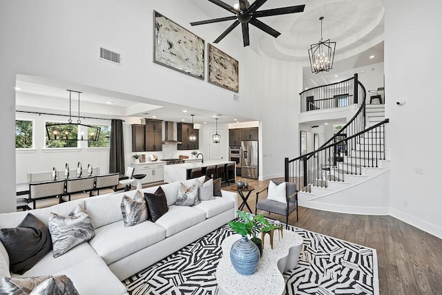 1220 Summer Moon Dr, Georgetown, TX 78628 - living room featuring a chandelier, wood finished floors, stairs, a ceiling fan, and a high ceiling