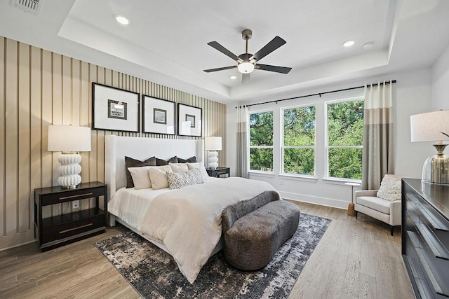 1220 Summer Moon Dr, Georgetown, TX 78628 - bedroom featuring a tray ceiling, wood finished floors, recessed lighting, and ceiling fan