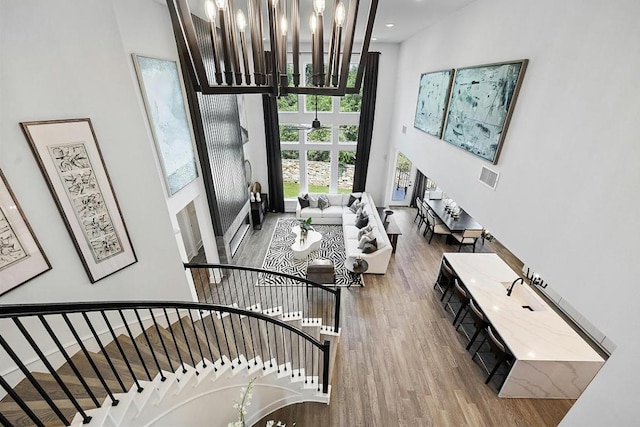 1220 Summer Moon Dr, Georgetown, TX 78628 - living room featuring a chandelier, wood finished floors, a towering ceiling, stairway, and recessed lighting