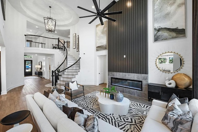 1220 Summer Moon Dr, Georgetown, TX 78628 - living area featuring a high ceiling, stairs, a fireplace, wood finished floors, and ceiling fan
