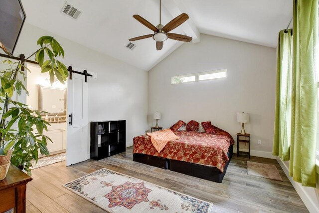 17 Shady Bluff Ct, Wimberley, TX 78676 - bedroom featuring a barn door, light wood-style floors, and ceiling fan