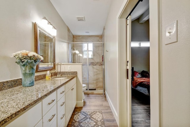 full bathroom featuring vanity, toilet, wood finished floors, visible vents, and a stall shower