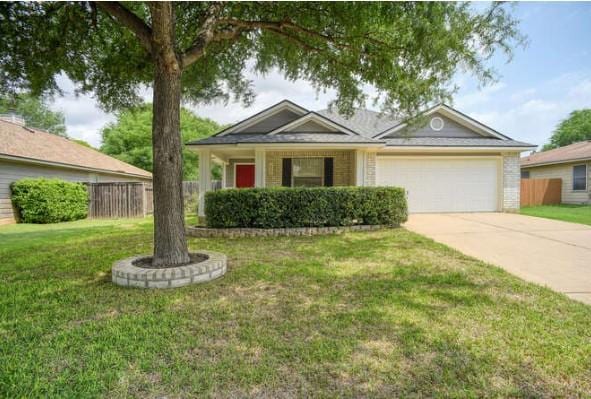 ranch-style home featuring concrete driveway, fence, a front lawn, and a garage